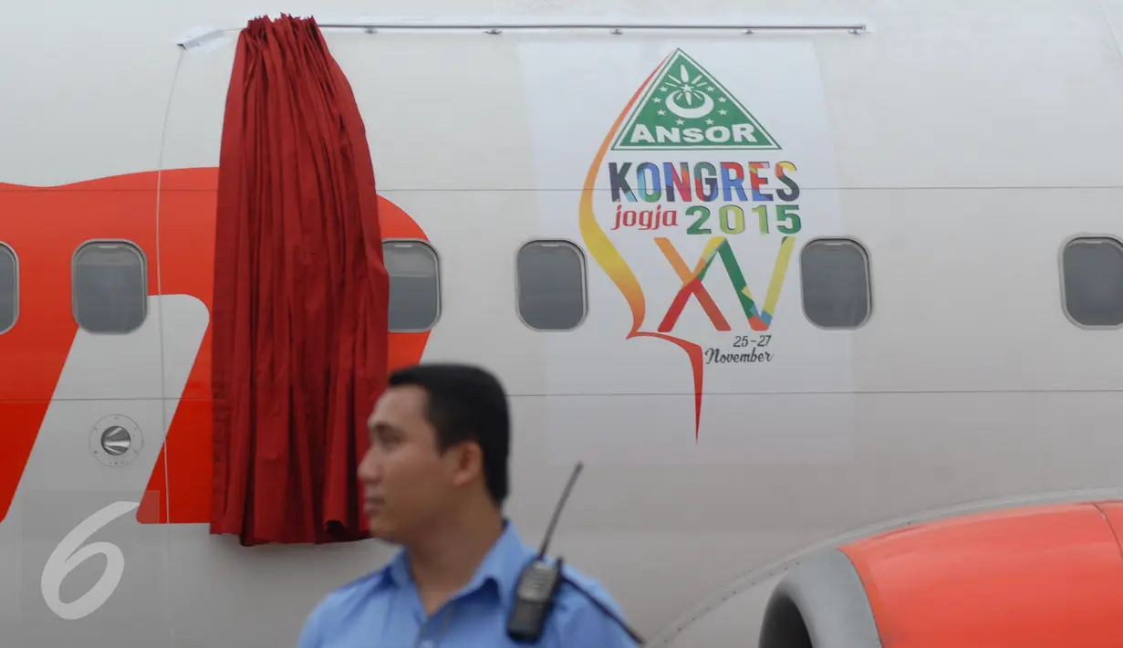 Petugas berdiri depan logo GP Ansor yang terpasang di badan pesawat di Bandara Soekarno Hatta, Tangerang, (24/11). Lion Air meluncurkan pesawat "Official Airline" dalam rangka Silaturahim Akbar dan Konsgres XV GP Ansor. (Liputan6.com/Angga Yuniar)