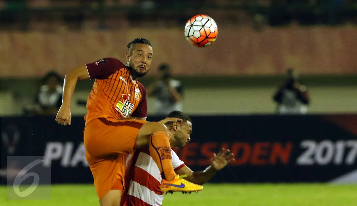 Bek PBFC, Yamashita Kunihiro (kiri) berebut bola dengan pemain Madura United saat laga 8 besar PIala Presiden 2017 di Stadion Manahan Solo, Sabtu (25/2). PBFC unggul adu penalti 5-4 (0-0). (Liputan6.com/Helmi Fithriansyah)