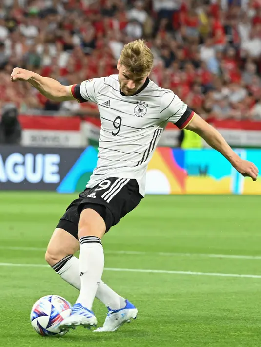 Penyerang Jerman, Timo Werner menembak bola saat bertanding melawan Hungaria pada pertandingan grup A3 UEFA Nations League di Puskas Arena di Budapest, Minggu (12/6/2022). Hasil imbang ini membuat Jerman menduduki tempat ketiga klasemen grup dengan tiga poin, sedangkan Hungaria mengumpulkan empat poin. (AFP/Attila Kisbenedek)