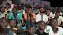 Suporter Senegal bereaksi saat menyaksikan laga babak 16 besar Piala Dunia 2022 saat tim kesayangan mereka melawan Inggris di Qatar, lewat layar video yang dipsang di fan zone di Dakar, Senin (5/12/2022) dini hari WIB. Senegal ditaklukkan Inggris dengan skor 0-3. (Photo by SEYLLOU / AFP)