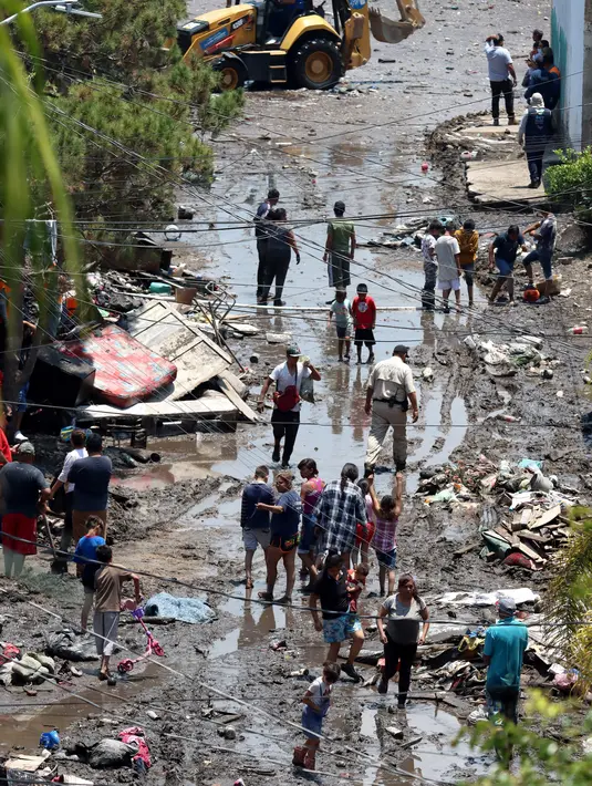 Pemandangan udara aktivitas warga di sepanjang jalan berlumpur setelah aliran El Seco meluap akibat hujan lebat di Zapopan, Jalisco State, Meksiko (26/7/2021). Luapan sungai menyebabkan banjir disertai lumpur dan sampah melanda Zapopan, kota di negara bagian Jalisco, Meksiko. (AFP/Ulises Ruiz)