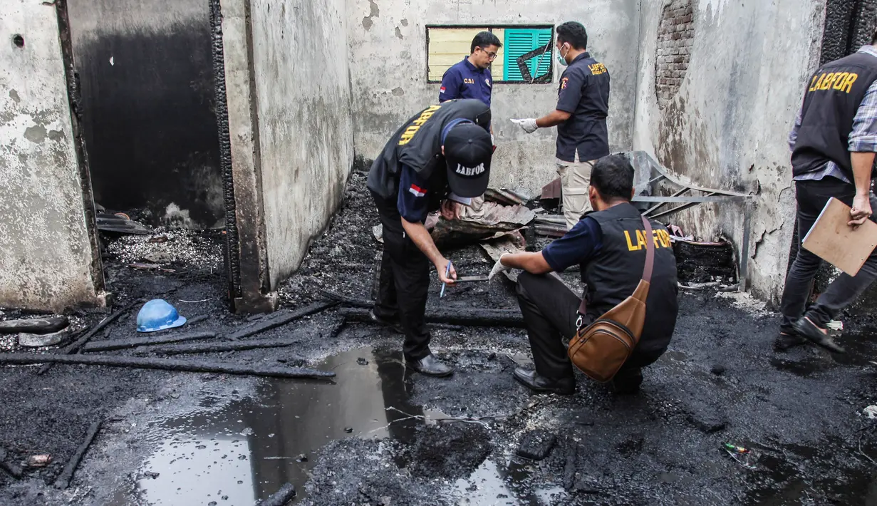 Tim penyelidik bekerja di lokasi kebakaran pabrik korek gas di Binjai, Langkat, Sumatera Utara, (21/6/2019). Korban tewas telah dievakuasi dari TKP ke Rumah Sakit Bhayangkara Polda Sumut di Kota Medan. (Ivan Damanik/AFP)