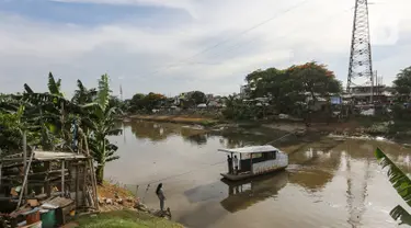 Perahu eretan membawa warga menyeberangi Banjir Kanal Barat, Jatipulo, Jakarta, Senin (31/01/2022). Jasa transportasi tradisional, perahu eretan yang beroperasi sejak tahun 1990 hanya dikenakan tarif Rp 2000 sekali menyeberang dari pagi hingga sore hari. (Liputan6.com/Fery Pradolo)