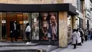 Pelanggan mengantre di pintu masuk sebuah toko pakaian pada hari pertama pelonggaran lockdown secara bertahap di Brussel, Senin (11/5/2020). Warga Belgia rela mengantre selama beberapa jam sebelum toko dibuka untuk berbelanja pertama kalinya sejak lockdown pada Maret lalu. (Kenzo TRIBOUILLARD/AFP)