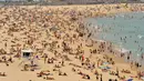 Suasana pantai Bondi ketika suhu udara panas meningkat di Sydney (21/12/2019). Pemerintah negara bagian tersebut juga sudah mendeklarasikan status darurat karena situasi saat ini membahayakan warga dan wisatawan. (AFP/Farooq Khan)