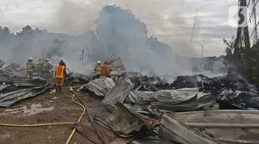 Petugas pemadam kebakaran melakukan pendingin di Pabrik penggilingan kapas,  Pasar Rebo, Jakarta Timur, Selasa (16/11/2021). Sudin Penanggulangan Kebakaran dan Penyelamatan (Gulkarmat) Jakarta Timur menurunkan 13  mobil pemadam kebakaran  untuk memadamkan api. (Liputan6.com/Herman Zakharia)