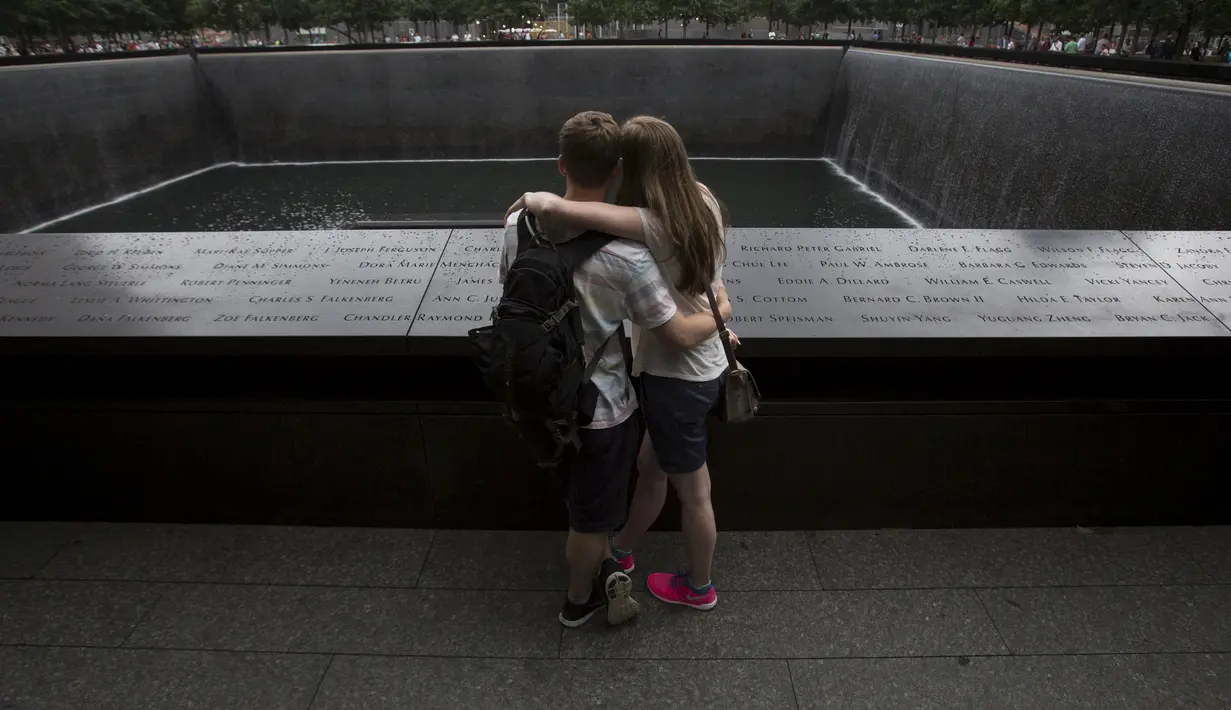 Warga berpelukan di depan The National September 11 Memorial di Lower Manhattan, New York, Kamis (10/9/2015). Masyarakat akan menggelar peringatan terkait tragedi 9/11. (REUTERS / Andrew Kelly)