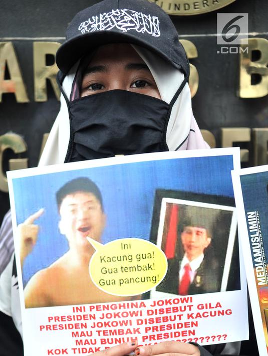 Massa Laskar Pembela Islam (LPI) menunjukkan poster tuntutan saat mengawal pemeriksaan Habib Bahar bin Smith di depan Gedung Bareskrim Polri, Jakarta, Kamis (6/12). Massa LPI menuntut keadilan hukum bagi Habib Bahar. (Merdeka.com/Iqbal Nugroho)