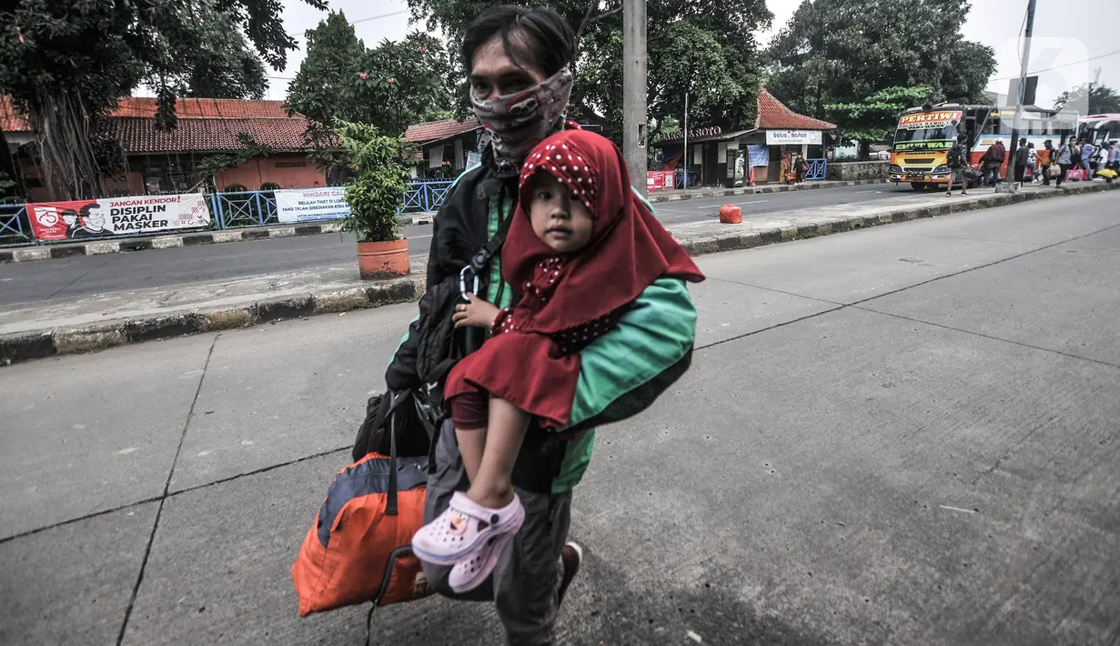 Pemudik membawa barang mereka seusai turun dari bus antarkota antarprovinsi (AKAP) di Terminal Kampung Rambutan, Jakarta, Minggu (23/5/2021). Hingga sore ini pemudik dari kota di Jawa Barat, Tengah, Timur, dan Sumatera terus berdatangan di Terminal Kampung Rambutan. (merdeka.com/Iqbal S Nugroho)