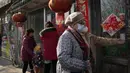 Warga berbaris untuk makan pangsit seperti yang biasa dilakukan selama hari titik balik matahari musim dingin di Beijing, China, Selasa (21/12/2021). Pangsit adalah makanan festival selama hari titik balik matahari musim dingin. (AP Photo/Ng Han Guan)