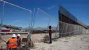 Seorang anak melihat pekerja dari Amerika Serikat saat membangun dinding perbatasan AS-Meksiko di Sunland Park, AS (09/9). Amerika Serikat dan Mexico merupakan dua negara yang memiliki batas geografis yang berdekatan. (REUTERS/Jose Luis Gonzalez)