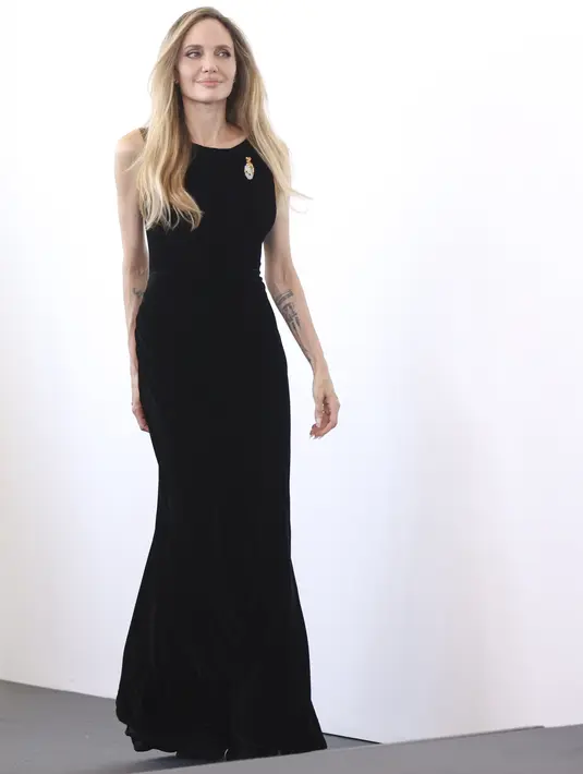 Itu adalah penampilan ketiga Angelina Jolie pada hari itu di acara tahunan tersebut. Sore harinya, ia menghadiri pemotretan untuk film Maria, mengenakan gaun hitam panjang dari labelnya sendiri, Atelier Jolie.  (Photo by Vianney Le Caer/Invision/AP)