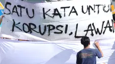 Warga menandatangani spanduk dukungan anti korupsi yang dibentangkan saat Hari Bebas Kendaraan di kawasan Bundaran HI, Jakarta, Minggu (10/12). Aksi dilakukan untuk memperingati Hari Anti-Korupsi Sedunia, 9 Desember. (Liputan6.com/Helmi Fithriansyah)