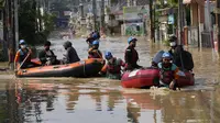 Warga duduk dalam perahu karet saat mereka mengungsi ke tempat yang lebih tinggi selama banjir di Bekasi, Jawa Barat, Kamis (17/2/2022). Hujan deras yang dikombinasikan dengan perencanaan pembuangan limbah kota yang buruk sering menyebabkan banjir besar. (AP Photo/Achmad Ibrahim)