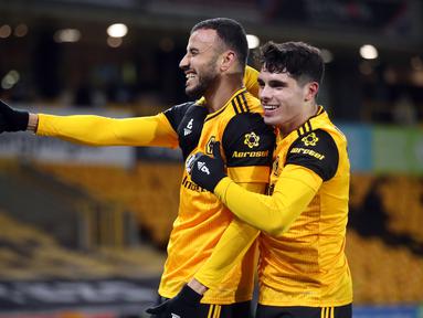 Gelandang Wolverhampton Wanderers, Roman Saiss (kiri) melakukan selebrasi usai mencetak gol ke gawang Tottenham Hotspur dalam laga lanjutan Liga Inggris 2020/21 pekan ke-15 di Molineux Stadium, Minggu (27/12/2020). Wolherhampton bermain imbang 1-1 dengan Spurs. (AFP/Carl Recine/Pool)
