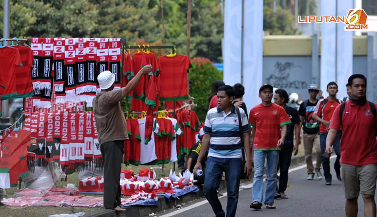 Di antara segelintir suporter, masih ada pedagang yang mengadu nasib menjajakan beragam aksesoris Timnas Indonesia di Stadion GBK Jakarta saat kualifikasi Piala AFC U19 Grup G (Liputan6.com/Helmi Fithriansyah)
