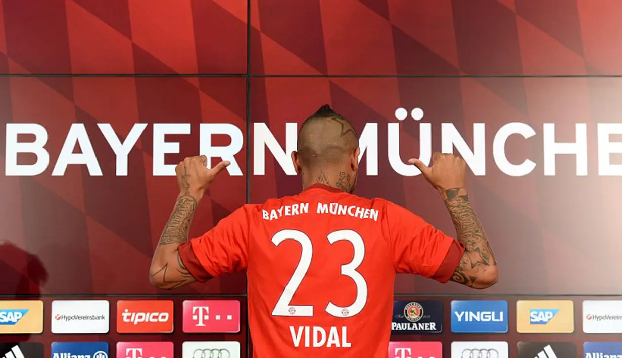 Pemain baru Bayern Munchen Arturo Vidal menunjukan kostum tim barunya dengan nomor punggung 23 saat jumpa pers di Munich, Jerman, Selasa (28/7/2015). (AFP Photo/Christof Stache)