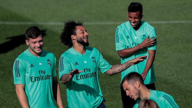 Bek Real Madrid Marcelo (dua kiri) bercanda dengan rekan-rekannya saat berlatih di kompleks latihan Valdebebas, Madrid, Spanyol, Senin (30/9/2019). Real Madrid bersiap jelang menjamu Club Brugge dalam laga Liga Champions. (AP Photo/Bernat Armangue)