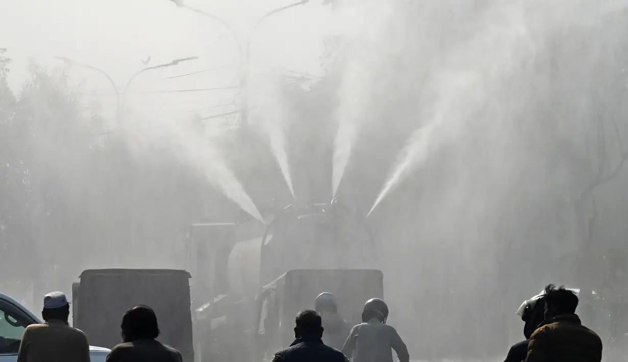 Dalam upaya menangani persoalan tersebut, Badan Air dan Sanitasi (WASA) Pakistan turun tangan melakukan penyemprotan air di sejumlah jalan raya. Harapannya, bisa meminimalisir polusi udara dan mengurangi kabut asap. (Arif ALI/AFP)