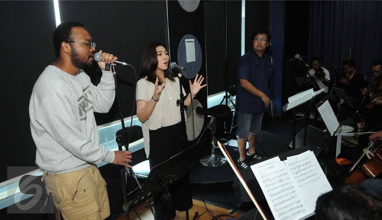 Isyana Sarasvati saat latihan bersama personel Dekat, Mohammed Kamga dan Erwin Gutawa Orchestra di kawasan Cilandak, Jakarta, Minggu (21/8). Isyana dan Kamga akan duet pada malam puncak HUT SCTV ke-26. (Liputan6.com/Helmi Afandi)