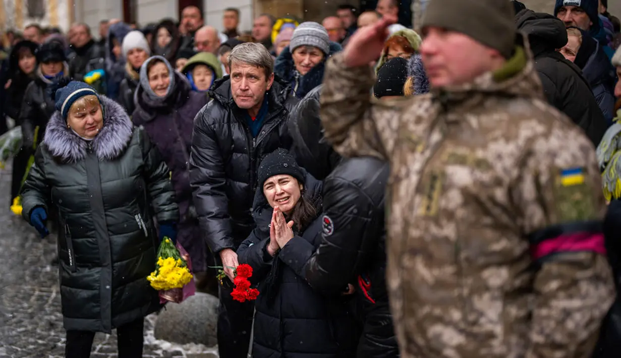 Anastasia (tengah) menangis ketika tentara membawa peti mati saudara laki-lakinya Oleg Kunynets, seorang prajurit militer Ukraina yang terbunuh di bagian timur negara itu, saat pemakamannya di Lviv, Ukraina, 7 Februari 2023. Memasuki hari ke-350 invasi Rusia ke Ukraina, korban jiwa terus berjatuhan di antara kedua belah pihak yang berseteru. (AP Photo/Emilio Morenatti)
