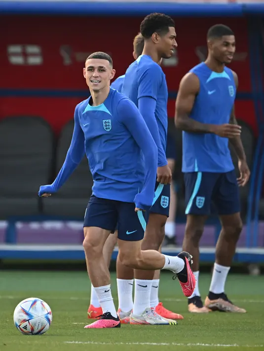 Penyerang Inggris #20 Phil Foden (Kiri) dan rekan satu timnya ambil bagian dalam sesi latihan jelang kontra Prancis pada perempat final Piala Dunia 2022, di Stadion Al Wakrah SC, selatan Doha, Jumat (9/12/2022). Inggris sejauh ini melaju cukup mulus, tetapi laga melawan Prancis akan menjadi ujian yang sebenarnya bagi mereka. (Paul ELLIS / AFP)