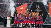 Para pemain Barcelona mengangkat trofi juara Piala Super Spanyol 2026 setelah mengalahkan Real Madrid dengan skor 3-2 dalam laga final yang berlangsung di King Abdullah Stadium, Jeddah, Arab Saudi, Minggu (11/01/2026) waktu setempat. (AP Photo/Altaf Qadri)