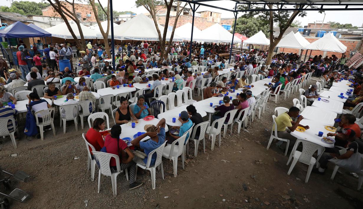 Pengungsi Venezuela makan siang di tempat penampungan Divina Providencia, La Parada, Cucuta, Kolombia, Senin (18/2). Tempat penampungan ini menyiapkan makanan kecuali hari Minggu. (AP Photo/Fernando Vergara)