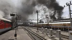 Asap mengepul dari kereta api yang dibakar pengunjuk rasa di stasiun kereta api Secundrabad di Hyderabad, India, Jumat (17/6/2022). Ratusan pemuda melampiaskan kemarahan dengan membakar gerbong kereta, merusak properti kereta api dan memblokir rel dan jalan raya dengan batu-batu besar sebagai serangan balasan. (AP Photo/Mahesh Kumar A)