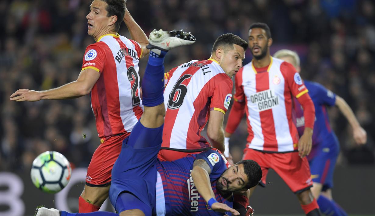 Aksi Luis Suarez melakukan tendangan salto saat berebut bola dengan para pemain Girona pada La Liga Santander di Camp Nou stadium, Barcelona, (24/2/2018). Barcelona menang telak 6-1. (AFP/Lluis Gene)