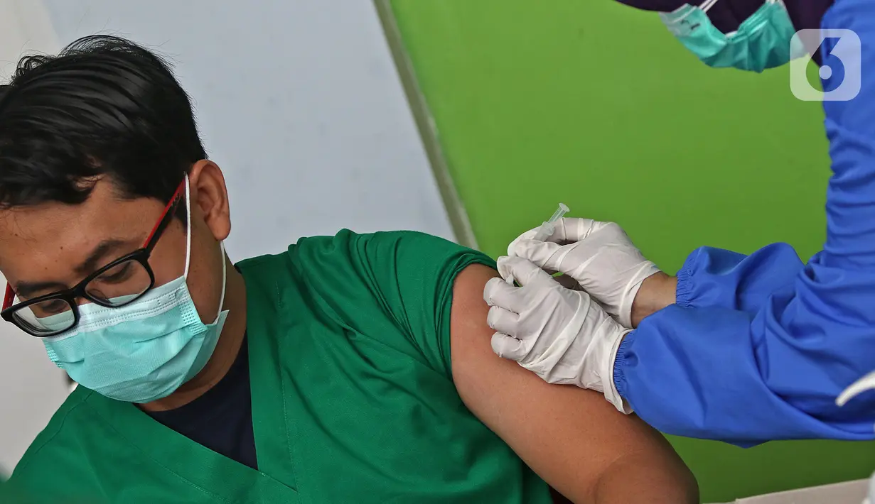 Seorang tenaga medis saat disuntik vaksin CoronaVac dari SinoVac di Rumah Sakit JatiSampurna, Bekasi, Jawa Barat, Kamis (28/01/2021). RS JatiSampurna melakukan Penyuntikan dosis kedua vaksin COVID-19 untuk para tenaga medis dan tenaga kesehatan yang bertugas. (Liputan6.com/Herman Zakharia)