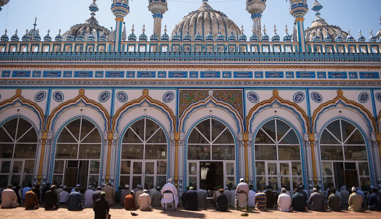 Umat Muslim berdoa di sebuah masjid sambil menjaga jarak sosial selama penguncian nasional yang diberlakukan pemerintah sebagai tindakan pencegahan terhadap coronavirus COVID-19, di Rawalpindi, Pakistan (19/4/2020). (AFP/Farooq Naeem)