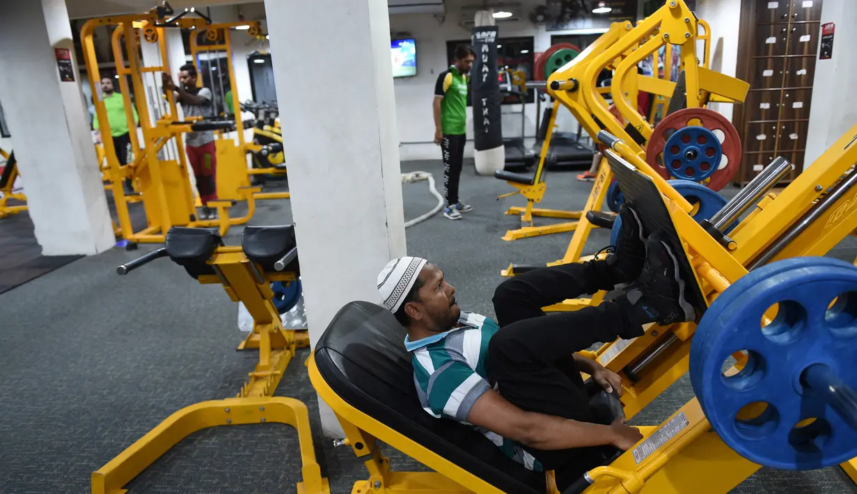 Seorang pria Muslim India saat berlatih di gym Ahmedabad Fitness Academy (AFA) di Ahmedabad (10/5/2019). Selama bulan suci Ramadhan, tempat gym ini tetap buka hingga larut malam untuk membiarkan anggota Muslim berolahraga setelah salat. (AFP Photo/Sam Panthaky)
