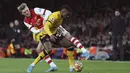 Bek Wolverhampton Wanderers Nelson Semedo berebut bola dengan gelandang Arsenal Martin Odegaard pada partai tunda pekan ke-20 Liga Inggris di Emirates Stadium, Jumat (25/2/2022) dini hari WIB. Arsenal menang dramatis 2-1 berkat dua gol di menit akhir. (AP Photo/Ian Walton)