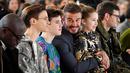 Legenda Timnas Inggris, David Beckham, bersama anak-anaknya saat menyaksikan peragaan busana koleksi Victoria Beckham pada acara London Fashion Week (16/2/2020). (Photo by DANIEL LEAL-OLIVAS / AFP)