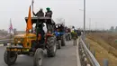 Para petani menaiki traktor berpartisipasi dalam unjuk rasa di Jalan Tol Kundli – Manesar – Palwal (KMP) di Kundli di negara bagian Haryana (7/1/2021). Reli traktor kemungkinan akan mempengaruhi lalu lintas di dalam dan sekitar New Delhi. (AFP/Prakash Singh)