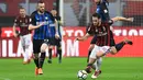 Gelandang AC Milan, Hakan Calhanoglu membawa bola dari kawalan pemain Inter Milan, Marcelo Brozovic dan Roberto Gagliardini pada pertandingan Liga Serie A Italia di stadion San Siro di Milan pada 4 April 2018. Calhanoglu resmi menyeberang ke klub tetangga Inter Milan. (AFP/Miguel Medina)