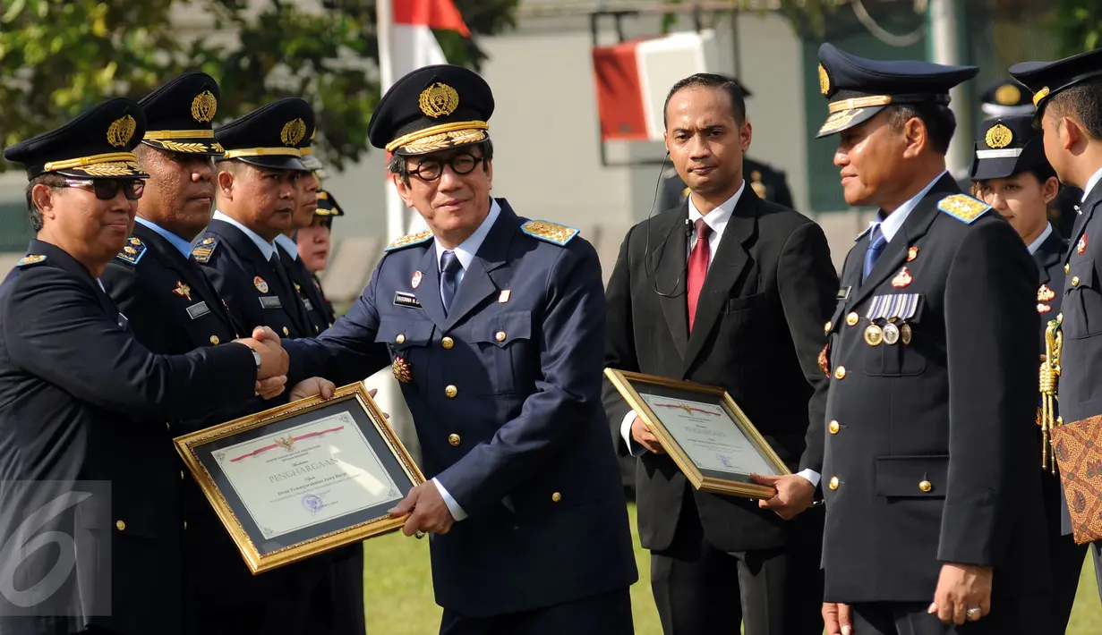 Menteri Hukum dan HAM, Yasonna H Laoly (tengah) memberikan penghargaan saat peringatan Hari Pemasyarakatan ke-52 di Lapas Cipinang, Jakarta, Rabu (27/4/2016). Upacara disertai deklarasi melawan narkoba oleh warga binaan. (Liputan6.com/Helmi Fithriansyah)