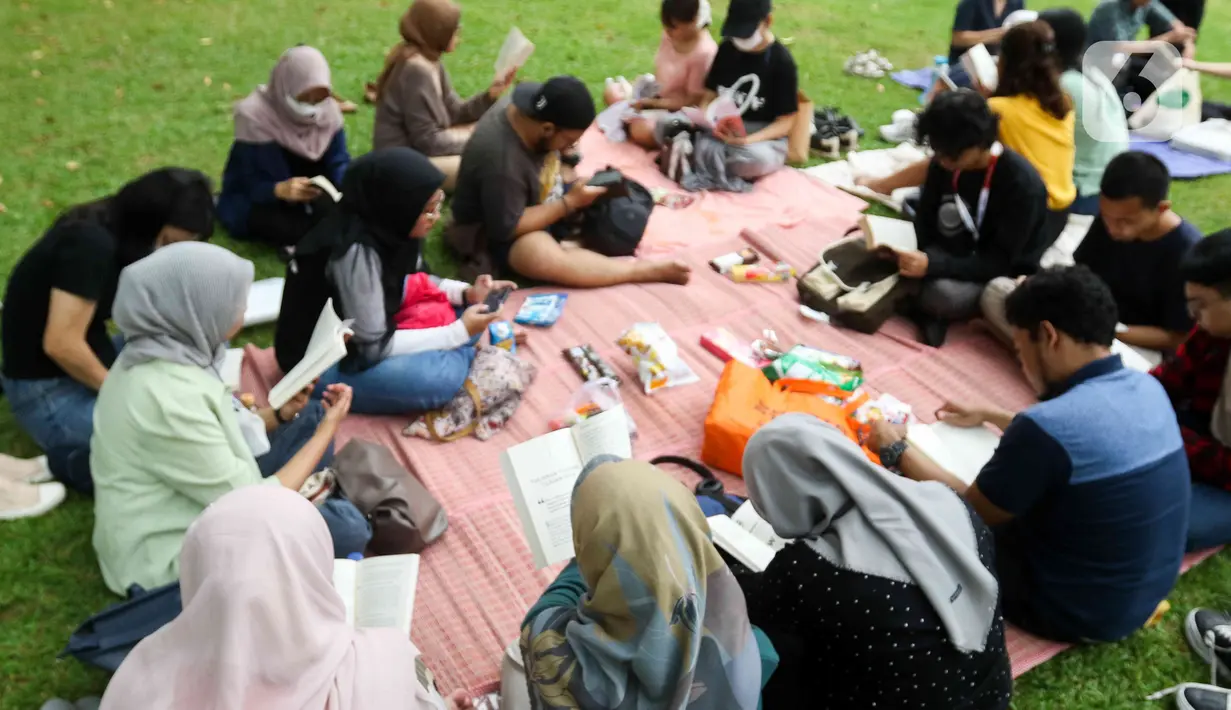 Sejumlah warga sedang membaca buku di taman Lapangan Banteng, Jakarta, Sabtu (27/5/2023). (Liputan6.com/Herman Zakharia)