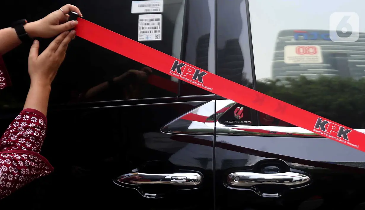 Petugas Komisi Pemberantasan Korupsi (KPK) memasang garis pembatas di samping mobil Alphard hasil sitaan penggeledahan rumah dinas Wakil Menteri Ketenagakerjaan (Wamenaker) Immanuel Ebenezer di kawasan Pancoran, Jakarta Selatan, Selasa (26/8/2025). (Liputan6.com/Helmi Fithriansyah)