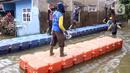 Petugas membuat jembatan apung saat banjir melanda Perumahan Periuk Damai, Tangerang, Banten, Selasa (23/2/2021). Adanya jembatan apung mempermudah warga saat melintasi banjir setinggi 2,5 meter di tempat tersebut. (Liputan6.com/Angga Yuniar)