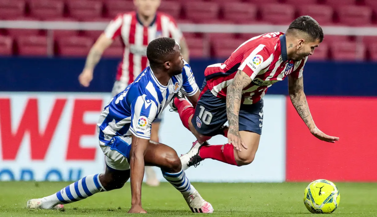 Striker Atletico Madrid, Angel Correa (kanan) terjatuh usai ditekel bek Real Sociedad, Modibo Sagnan dalam laga lanjutan Liga Spanyol 2020/2021 pekan ke-36 di Wanda Metropolitano Stadium, Rabu (12/5/2021). Atletico menang 2-1 atas Sociedad. (AP/Bernat Armangue)