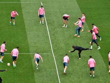 Para pemain Atletico Madrid melakukan pemanasan selama sesi latihan di stadion Parc OL di Decines-Charpieu (15/5). Atletico Madrid akan bertanding melawan wakil Prancis, Marseille pada babak final Liga Europa. (AFP Photo/Jean-Philippe Ksiazek)