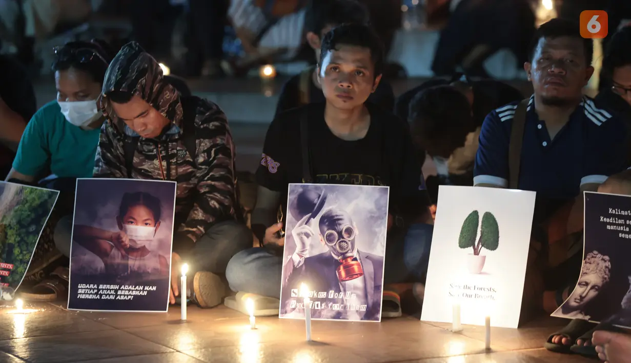 Sejumlah poster yang dibawa simpatisan masyarakat turut mewarnai aksi solidaritas dan doa bersama untuk korban kebakaran hutan dan lahan (karhutla) di Tugu Proklamasi, Jakarta, Senin malam (19/10/2026). (KLY/Budy Santoso)