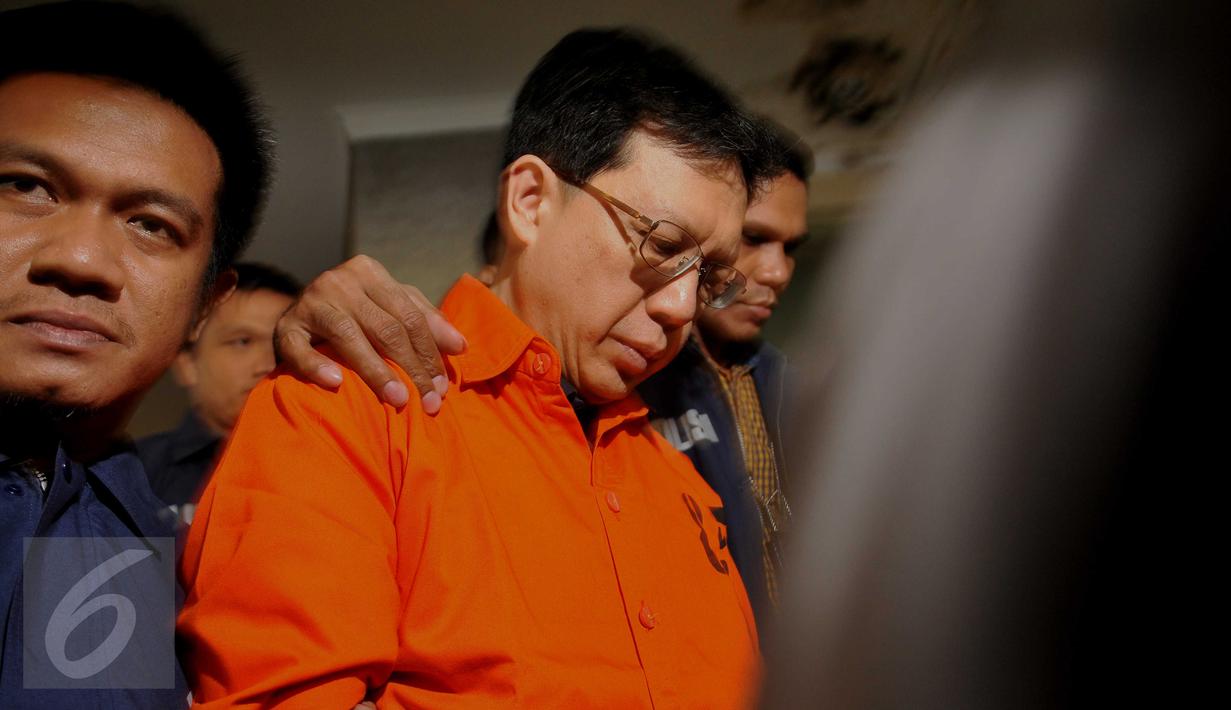 Buronan ‎kasus korupsi dana nasabah Bank Century, Hartawan Aluwi tampak berjalan menunduk saat keluar dari Bareskrim Mabes Polri, Jakarta, Jumat (22/4). Hartawan dibawa ke Kejagung dengan pengawalan ketat kepolisian. (Liputan6.com/Gempur M Surya)