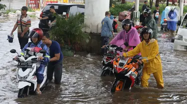 Pengendara terpaksa mendorong motornya yang mogok akibat memaksa melintasi banjir yang menggenangi jalan Ciledug Raya, Jakarta Selatan, Sabtu (6/7/2024). (Liputan6.com/Angga Yuniar)