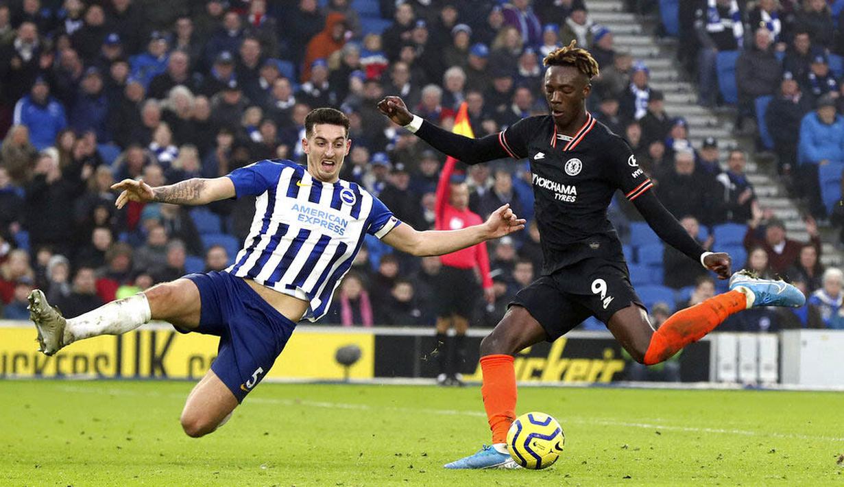 Pemain Brighton and Hove Albion, Lewis Dunk, berusaha menghadang tendangan striker Chelsea, Tammy Abraham, pada laga Premier League di Stadion AMEX, Rabu (1/1/2020). Kedua tim bermain imbang 1-1. (AP/(Gareth Fuller)