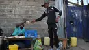 Artis hip hop Kenya Henry Ohanga alias Octopizzo yang berasal dari Kibera kumuh terbesar di Kenya di Nairobi, membeli makanan ringan dari penjual pinggir jalan saat berkunjung ke Kibera pada 16 Januari 2018. (AFP Photo/Tony Karumba)