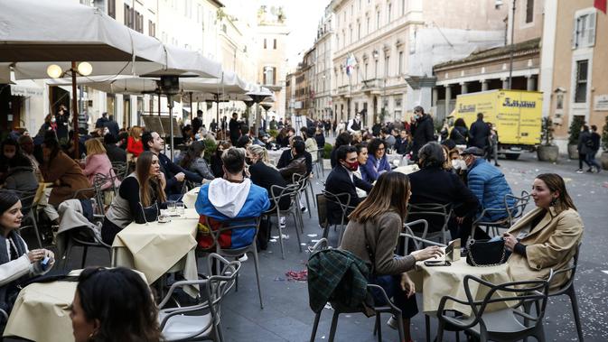 Orang-orang menikmati waktu bersantai di sebuah kafe menyusul pembatasan COVID-19 yang mulai dilonggarkan di Roma, Italia, Sabtu (6/2/2021).Italia adalah salah satu negara paling terdampak seama gelombang pertama pandemi virus corona COVID-19. (Cecilia Fabiano/LaPresse via AP)