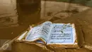 Sebuah kitab suci Al Qur'an dilumuri air lumpur usai banjir menggenangi masjid komplek Pondok Gede Permai, Bekasi, Jumat (22/4). Banjir di perumahan tersebut merendam lebih dari 500 rumah yang dihuni ribuan warga. (Liputan6.com/Fery Pradolo)